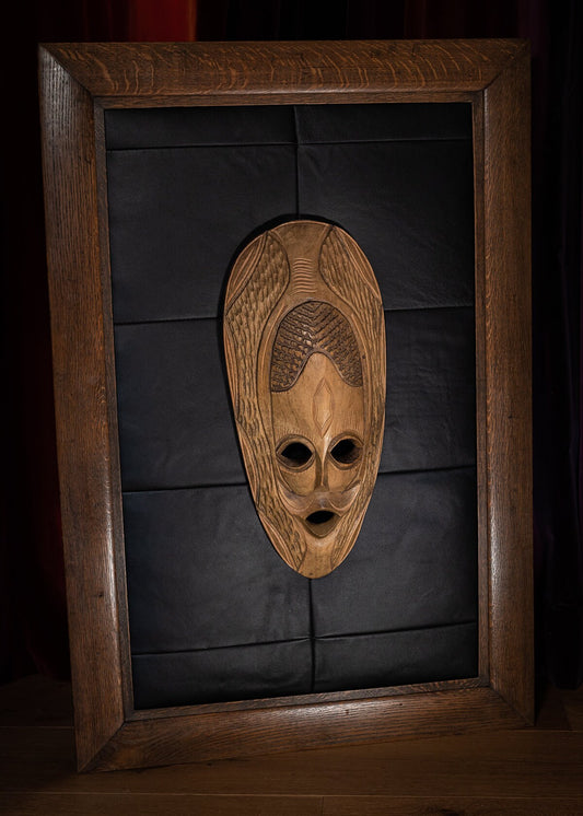 Unique wall art of a Tribal Mask in a antique solid Oak frame.