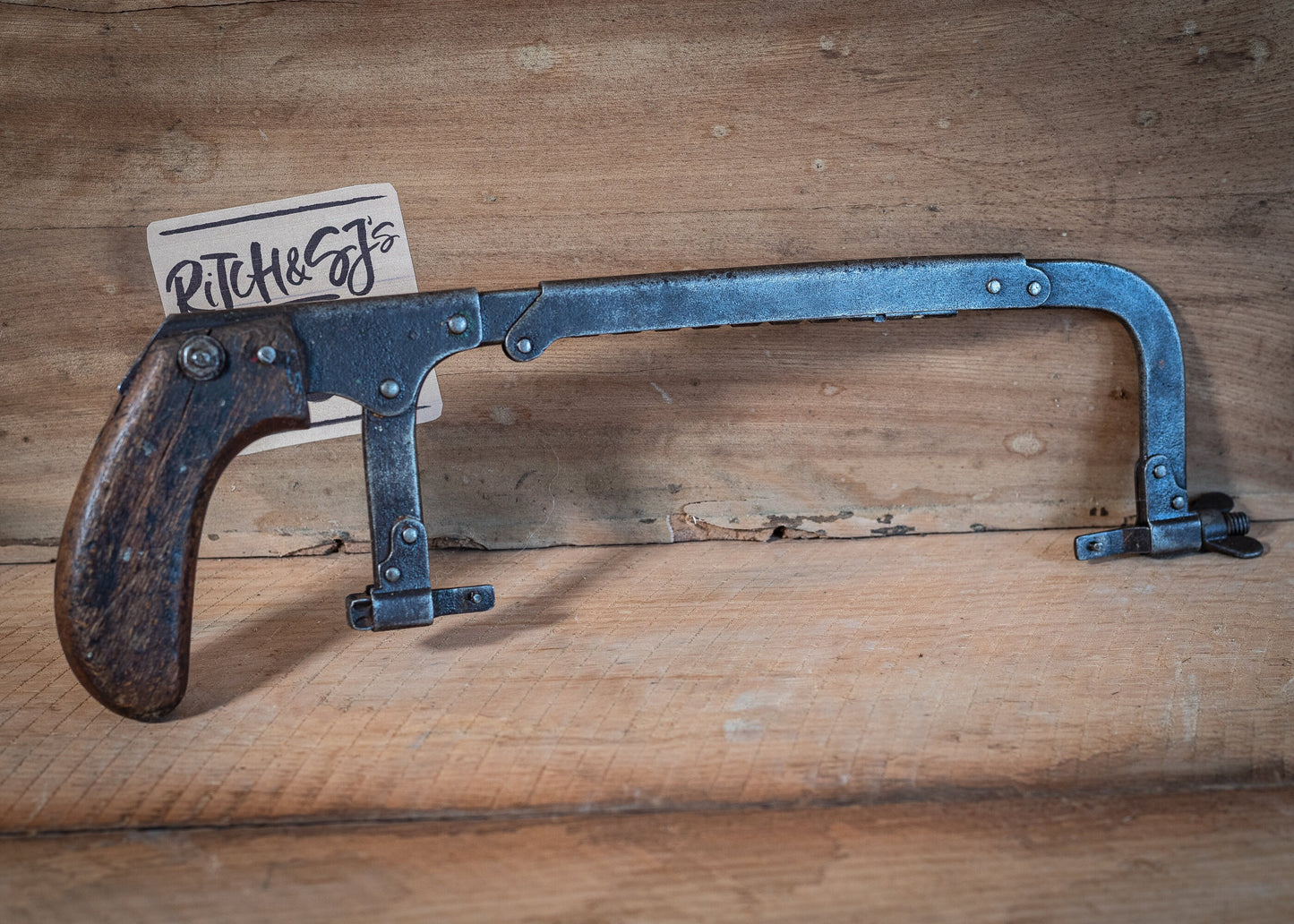 Vintage adjustable length hacksaw, with pistol style, wooden grip.