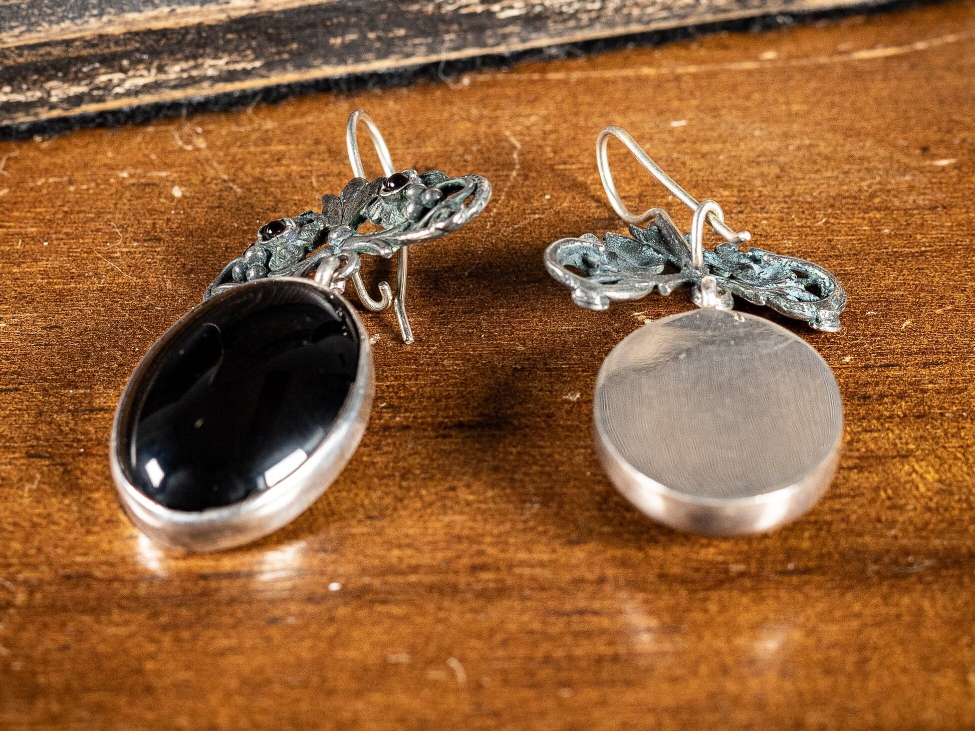 Silver earings with large black oval stone and two small red gemstones