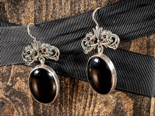 Silver earings with large black oval stone and two small red gemstones