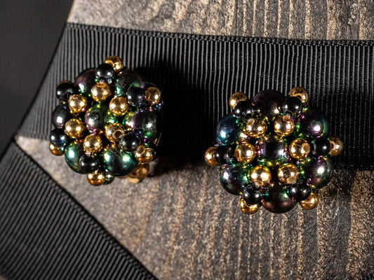 Vintage clip on earrings with peacock, gold and black beads in a flower cluster.