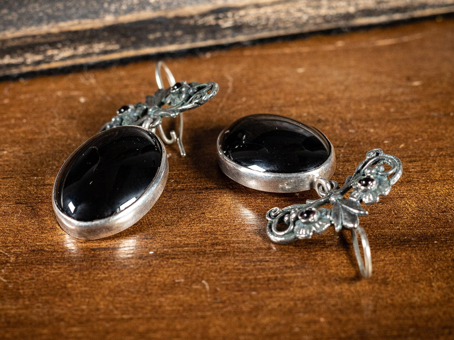 Silver earings with large black oval stone and two small red gemstones