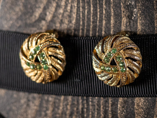 Vintage clip on earrings in a knot style, gold metal with nine green glass stones.