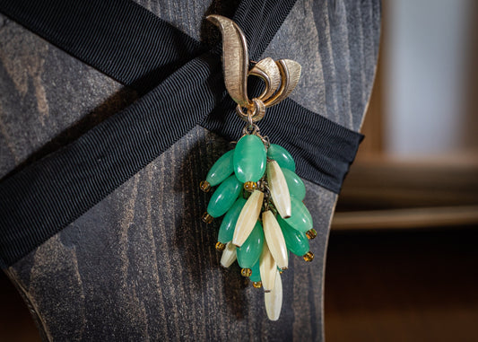 Vintage brooch with green and white charms